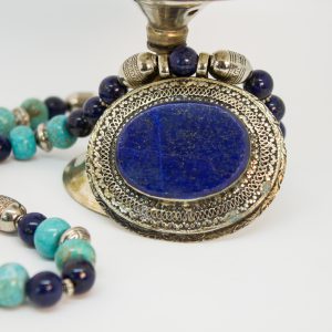 Eine Halskette aus Türkis und Lapislazuli. In der Mitte hängt ein 6 cm großer oval förmiger Anhänger aus Alpaka und Lapislazuli. Das Farbenspiel aus Türkis und azurblauen Lapislazuli schenkt diese Kette ein orientalischen Charakter und macht sie zu einem absoluten Eyecatcher.